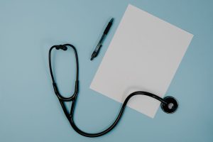 Flat lay of stethoscope, blank paper, and pen on blue surface — Commercial Dumbbells Engineered for Durability and Heavy Use