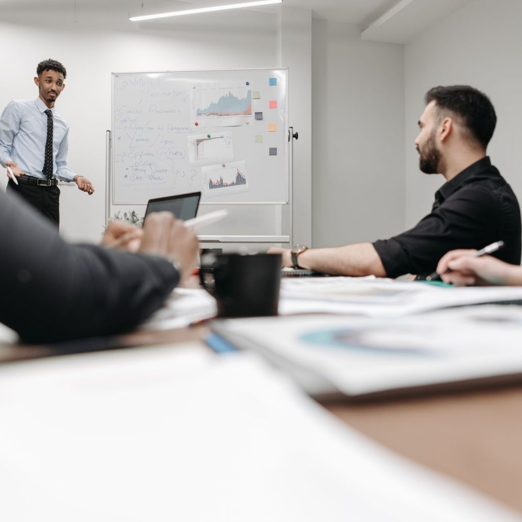 Corporate team during a presentation in an office setting, featuring discussions and planning. — Discover Greenhouses for Sal
