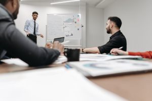 Corporate team during a presentation in an office setting, featuring discussions and planning. — Discover Greenhouses for Sal