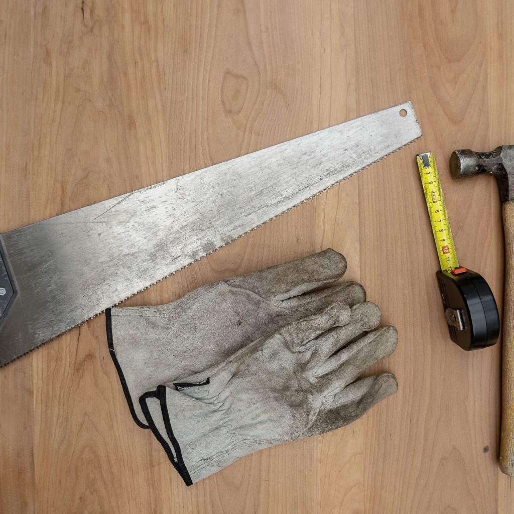 Flat lay of essential carpentry tools including a saw, hammer, and tape measure on wooden surface. — "Doral Windows: Combinin