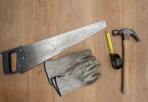 Flat lay of essential carpentry tools including a saw, hammer, and tape measure on wooden surface. — "Doral Windows: Combinin