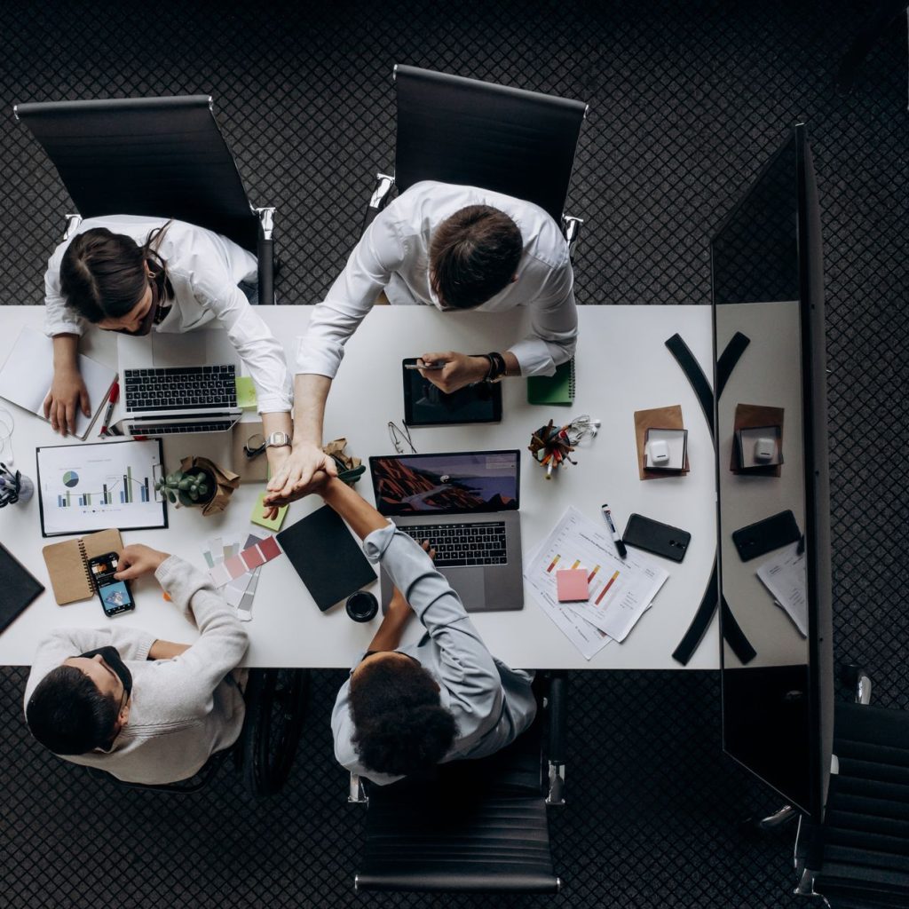 High angle view of colleagues collaborating around a conference table in a modern office setting. — Elevating Patient Care: T