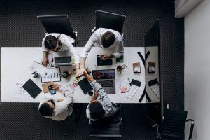 High angle view of colleagues collaborating around a conference table in a modern office setting. — Elevating Patient Care: T