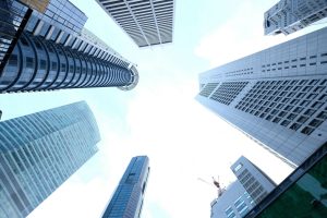 A striking upward view of various skyscrapers in an urban setting against a clear sky. — Green Oasis Unveiled: Journeying Thr