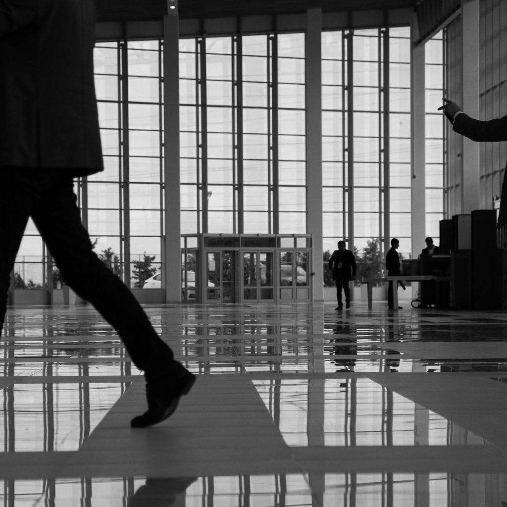 Business professionals walk through a modern, glass-paneled indoor space. — Grow Your Channel Fast: The Benefits of Buying Yo