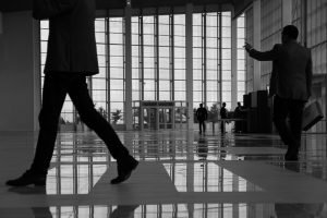 Business professionals walk through a modern, glass-paneled indoor space. — Grow Your Channel Fast: The Benefits of Buying Yo