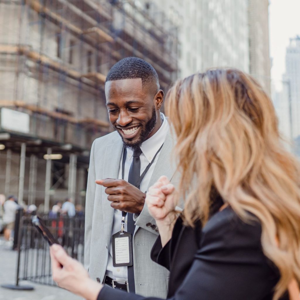 Two business professionals engage in lively conversation on an urban street, sharing insights. — How Bill Hutchinson Is Shapi