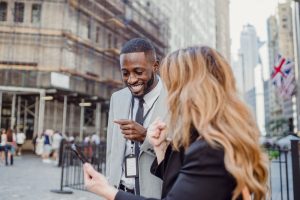 Two business professionals engage in lively conversation on an urban street, sharing insights. — How Bill Hutchinson Is Shapi