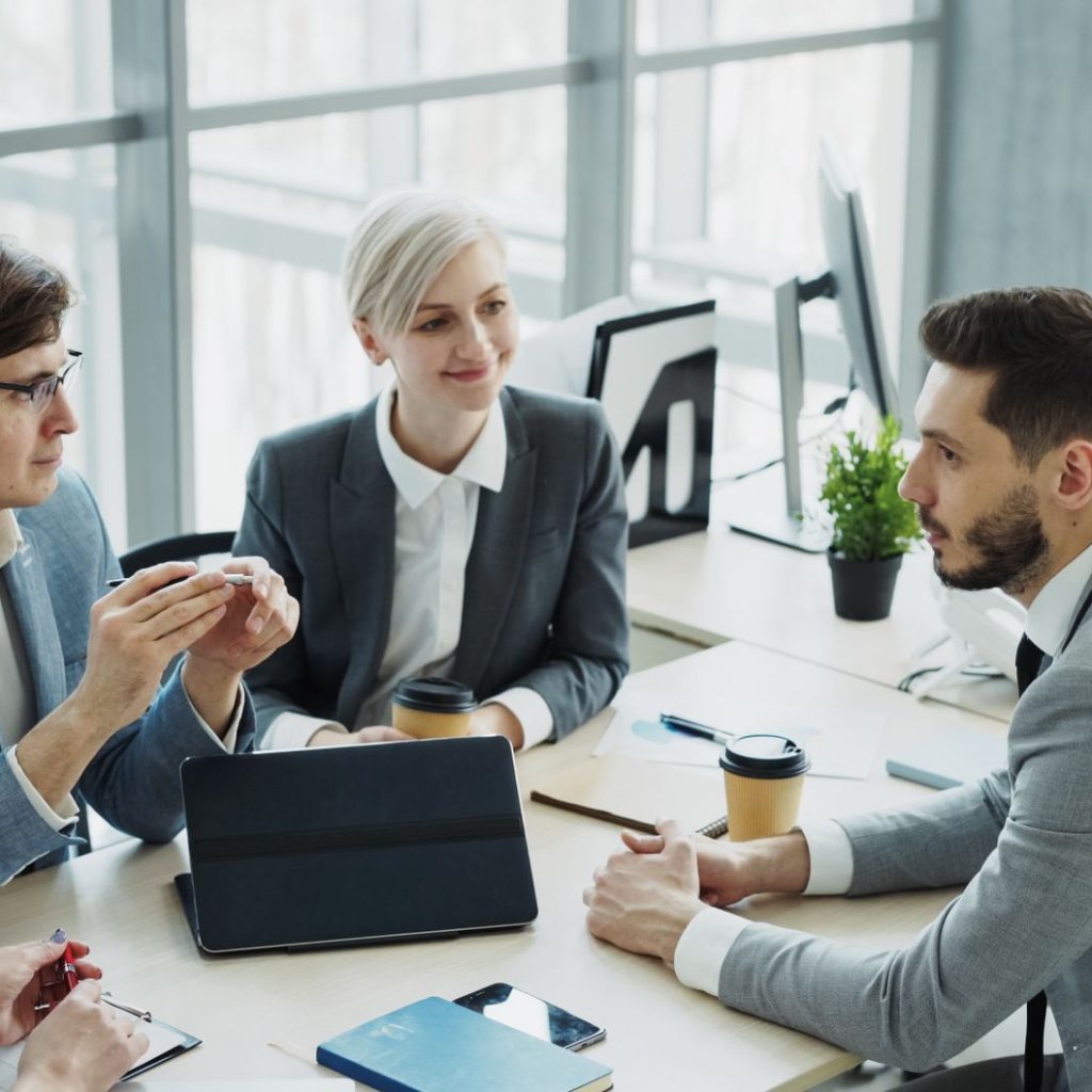 Group of professionals having a discussion in a modern office setting with natural light. — NFM Lending Offers Flexible Loan