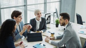 Group of professionals having a discussion in a modern office setting with natural light. — NFM Lending Offers Flexible Loan
