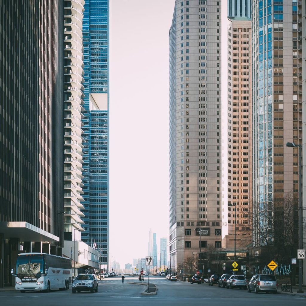 Vibrant city street scene with tall skyscrapers and city life full of cars and pedestrians. — YACSS SEO Conference 2024: The